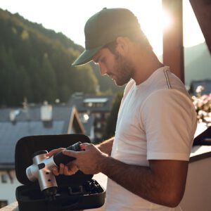 An image of a man holding the hyperice hypervolt.