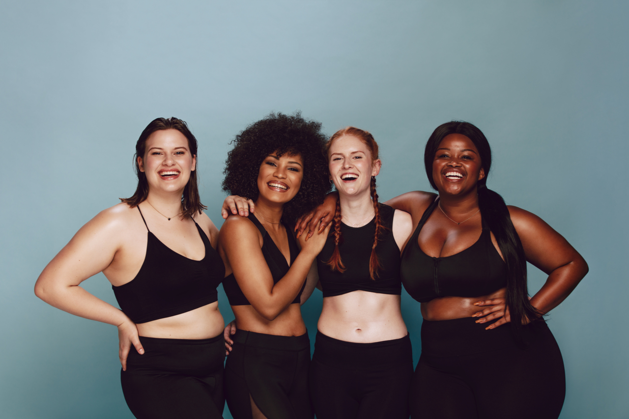 A group of multi-racial woman wearing black sporty attire having fun together.