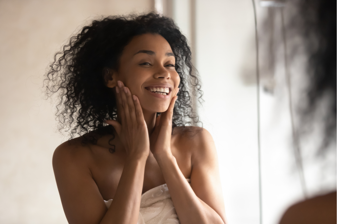 Woman feeling good while looking at the mirror after a shower.