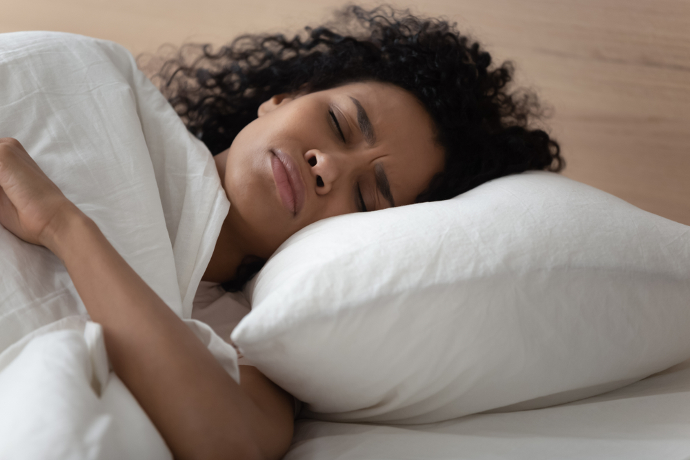 Close up african woman lying in bed has nightmares bad sleeping