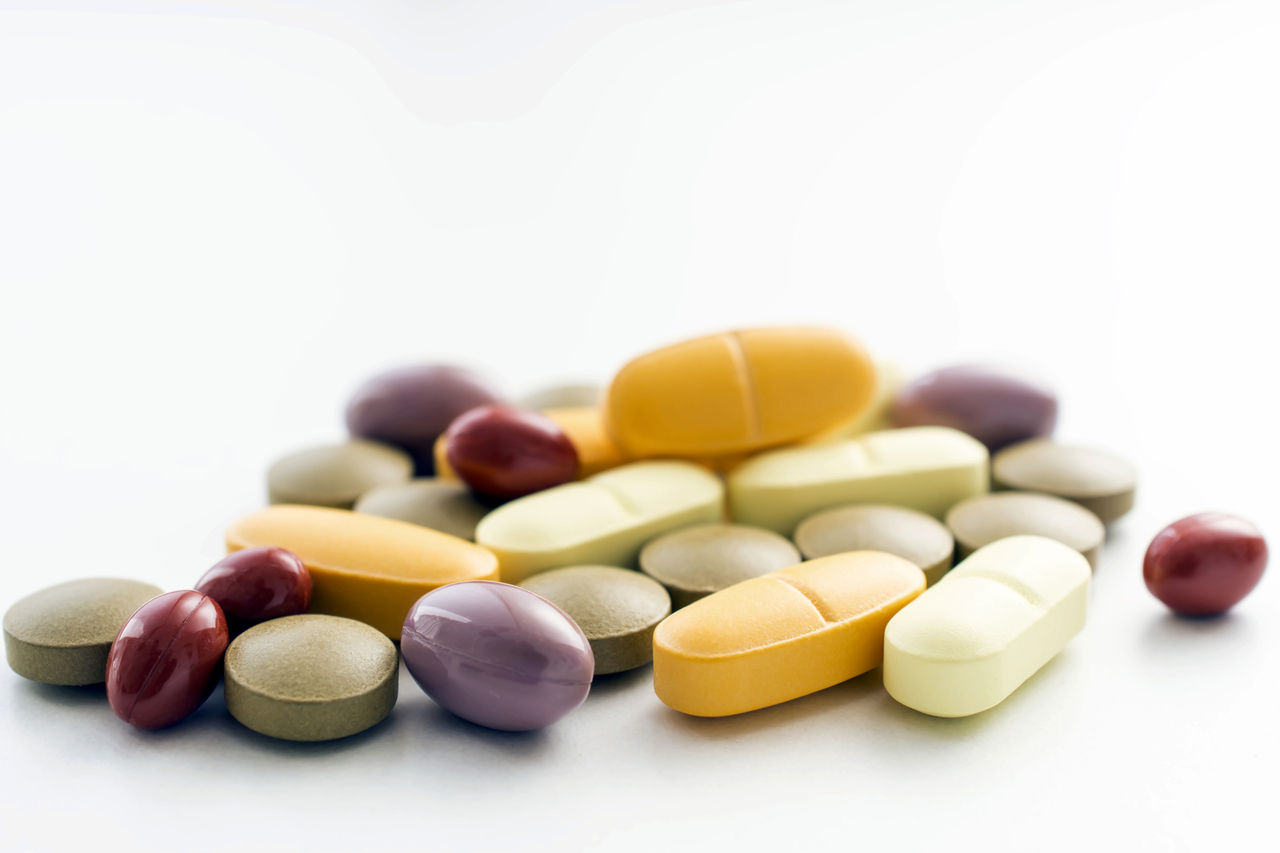 Vitamins and minerals pills on a white background.