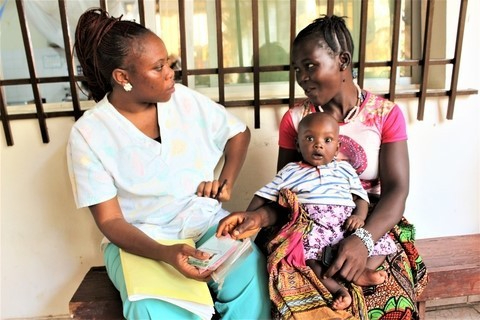 An obstetrician checking up on a woman with a baby.