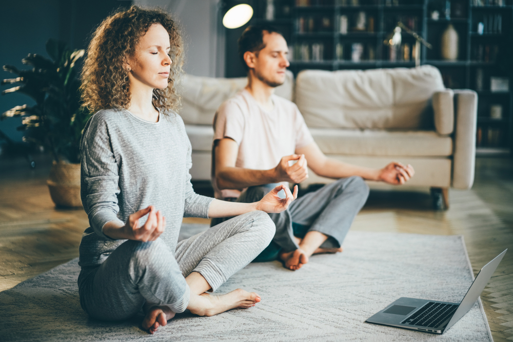 Calm couple in pajamas meditating