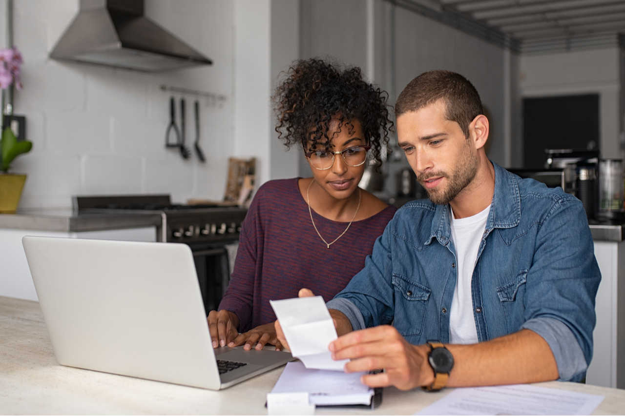 A couple budgeting their money on their bills to have financial stability.