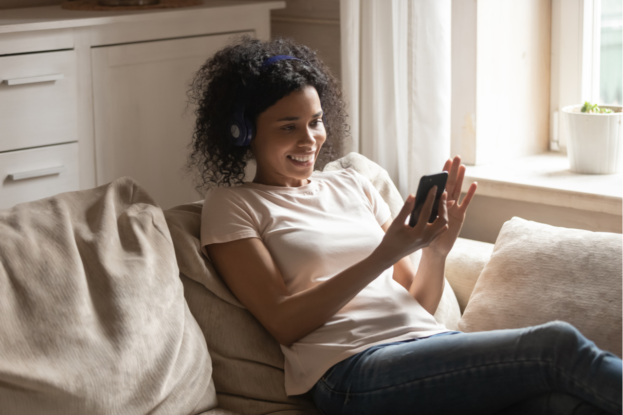 A woman listening to music while on a video call with a friend.