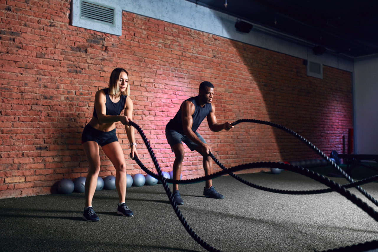 Interracial family couple exercising with Pro Battle Ropes With Anchor Strap Kit.