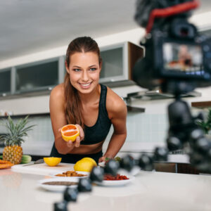 Young woman recording food based video content on camera.