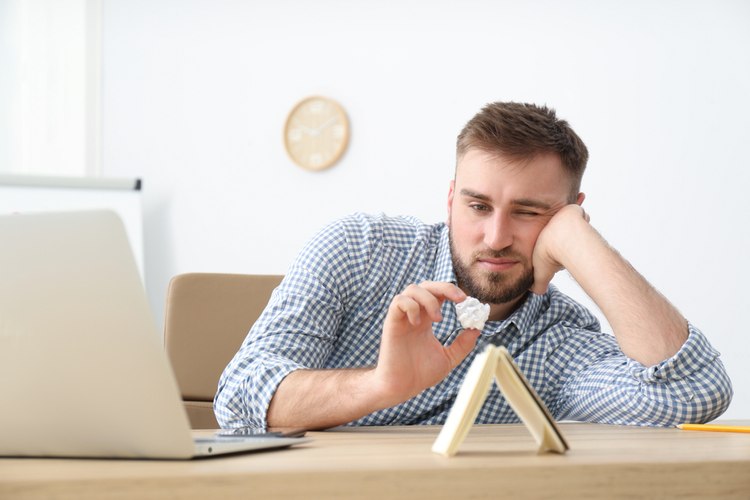 Lazy young office employee dealing with chronic procrastination at work