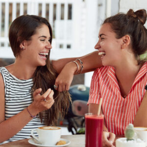 Two women at lunch laughing with each other